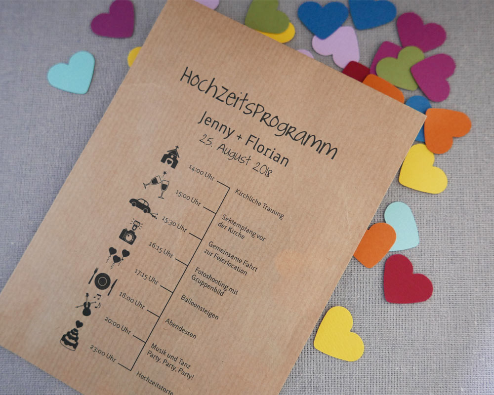 Hochzeitsprogramm auf Kraftpapiertüte gedruckt mit farbigen Konfettiherzen